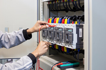 Electrical engineer tests the operation of the electric control cabinet on a regular basis for maintenance.	