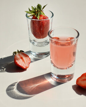 strawberry compote tincture with ice in glass glasses with strawberries and ice cubes