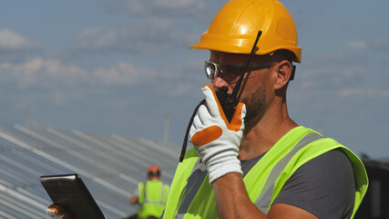 Solar farm engineer giving instructions on radio