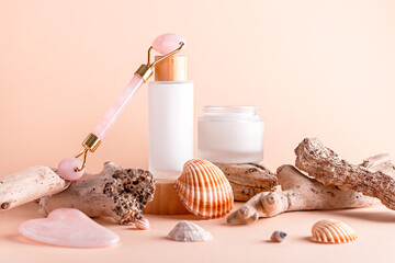 Scincare cosmetics, facial moisturizer, gua sha beauty roller on podiums with seashells