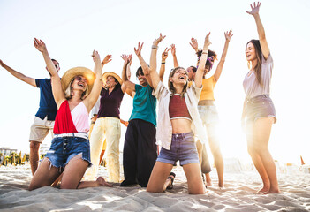 Multi age group of people with arms up dancing at summer beach party - Big young family having fun moments outdoor - Joy, lifestyle, friendship and holidays concept