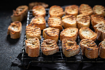 Hot and fresh toasted wholegrain bread on dark table.