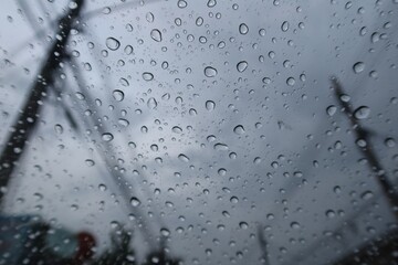 Abstract raindrops on car windshield, sky background, rainy season, images for nature background, selectable focus.
