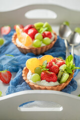 Homemade mini tart with strawberries and kiwi. Sweet fruit dessert.