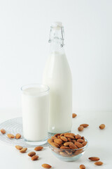 A glass with almond milk and the bowl with almonds