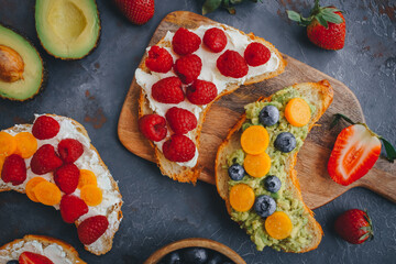 Breakfast, Croissant sandwiches with berries and avocado, Delicious summer food, Top view on a dark background