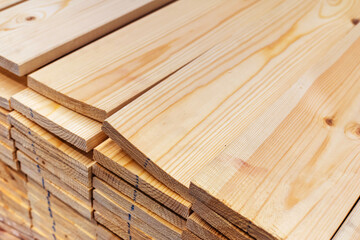 Many boards are in the warehouse of the hardware store. Wholesale and retail trade in timber. Close-up