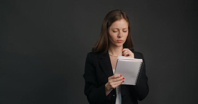 Vexed and angry woman in black suit crosses out hes notes in the notepad, 4k Prores HQ 120 fps