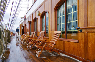 Outdoor teak promenade patio terrace balcony deck with deck chairs on luxury sailing windjammer Sea...