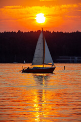 Sailboat in the background of the setting sun on the lake in Olsztyn - Warmia and Masuria, Poland, Europe
