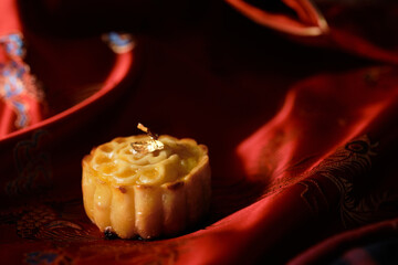 Mooncake a Chinese traditional pastry for Mid-Autumn festival. set on red chinese fabric.