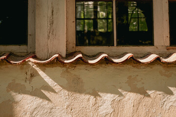 An old window in an old building of the last century. shadows from windowsill on wall. orange yellow painted wall