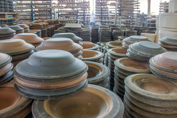 A large number of ceramic plates standing on the floor in columns at a porcelain factory and a space for copying in the Moscow region