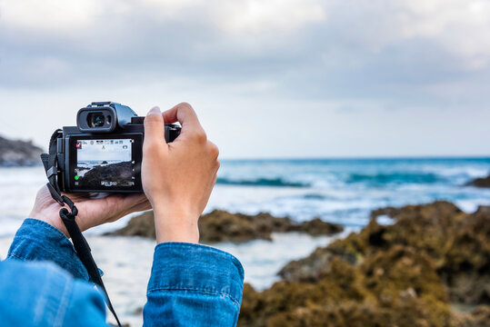 Close-up of a young female tourist taking photos on the Kenting coast of Pingtung, Taiwan.