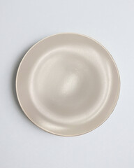 New luxury plate view from above on a isolated white background. Top view. Porcelain beige saucer. Trendy tones. Flat lay view.