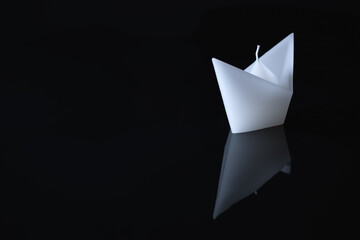 A white boat on a black background with a reflection. Minimalistic picture.
