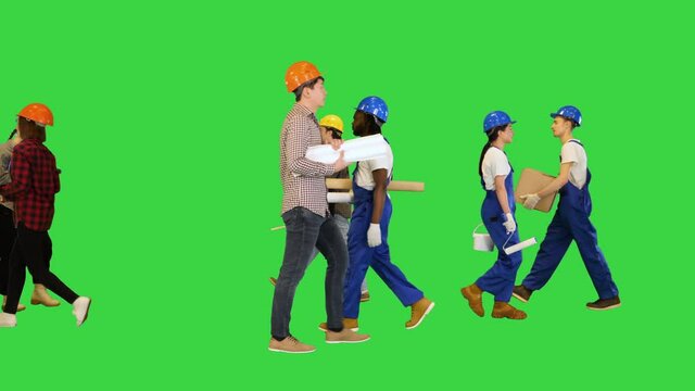 Many people of different construction professions walking by on a Green Screen, Chroma Key.