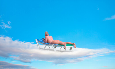 Blur of a blondie woman sunbathing on the clouds - obrazy, fototapety, plakaty