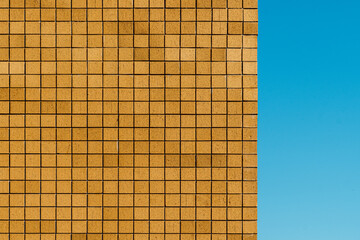 Brick facade of a modern building with and blue sky background in business district