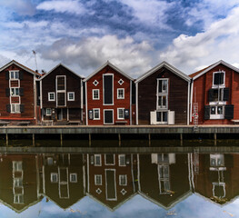 red and brown wooden warehouses along the waterfront in Hudiksvall