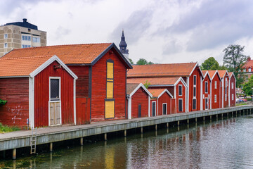 red and brown wooden warehouses along the waterfront in Hudiksvall