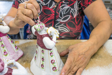 LIKINO-Dulyovo, Moscow Region, Russia-July, 8, 2021: a woman with a hidden face paints a ceramic...