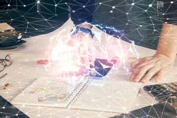 Double exposure of man's hand holding and using a digital device and brain hologram drawing. Data concept.