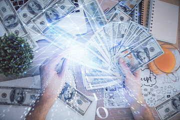 Multi exposure of technology drawing hologram and us dollars bills and man hands. Data concept