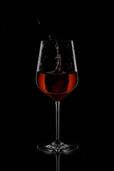 
Splash in glass with drink on black background