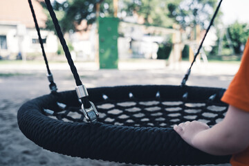 Child moves the swing back and forth because he is sad that he is all alone in the playground