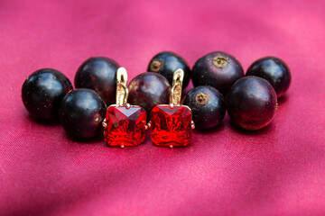gold earrings on the leaves.Handmade red and black earrings. Isolated.