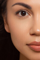 Naklejka premium Closeup of beauty woman with clean shiny skin and natural cosmetics. Beautiful grey eyes and plump lips of a well-groomed girl demonstrate spa procedures, injections in a beauty parlor