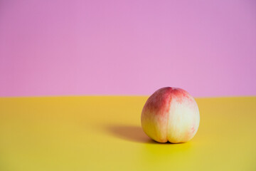1個の桃　黄色とピンクの背景