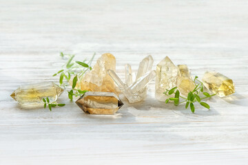 gemstones crystal minerals and green leaves on wooden white background. Magic Rock for Crystal...