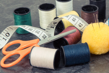 Spools of thread, needle, tape measure and scissors. Accessories for embroidery and sewing