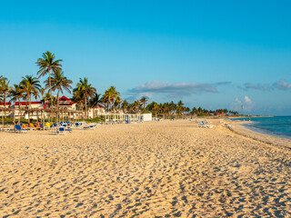 Cayo Coco, Cuba, 16 may 2021: Sandy beach of the hotel Tryp Cayo Coco with sun loungers and tall palm trees. People relax and sunbathe near the ocean on sun loungers.