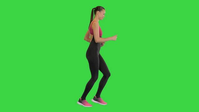 Confident beautiful fit girl jogging on a Green Screen, Chroma Key.