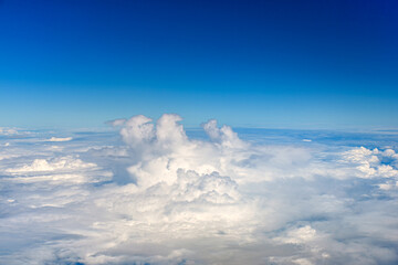 Clouds against blue sky view through an airplane window for a background.
