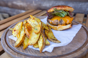 Tasty hamburger with french fries on the table.