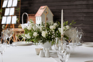 Table centerpiece with white and green floral arrangement in vase.