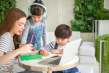happy loving family. pretty young mother reading a book and drawing to her daughter and son.Mother teach Asian preschool student do homework by reawing by a color.