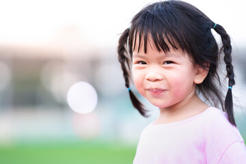 Portrait of Asian face child girl sweet smile. Happy kid with blurred bokeh background in the...