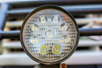 Round led light on off road car close up shot, focus on the dirt spots.
