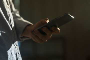 Close-up of man using mobile phone for searching information in internet. Persons hand holding...