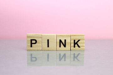 word pink made of wooden letters on a pink background