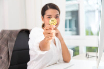 Asian businesswoman holding gold bitcoin, blockchain and bitcoin concept.