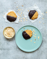 Chocolate Coated Oatmeal Cookies - with a bowl of oatmeal and bottle of milk - flatlay
