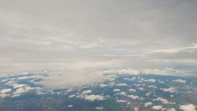 aerial view fly above clouds. airplane window view blue sky down to land. fluffy clouds in ozone level. atmosphere in cloudy sky rainy season. party cloudy weather forecasting nature background.