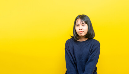 Portrait of a young beautiful woman in studio on yellow background.