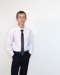 A boy in a white shirt and tie on a light background